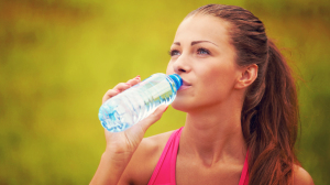 fit-woman-drinking-water-in-park