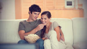 young-couple-on-the-couch-watching-a-movie-together